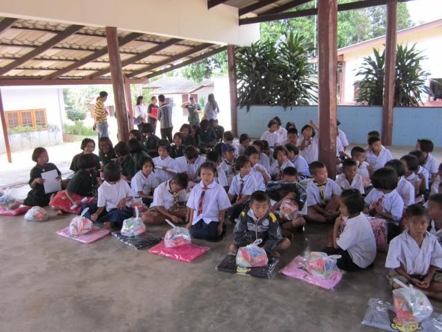 Children sitting in rows at an outdoor school assembly